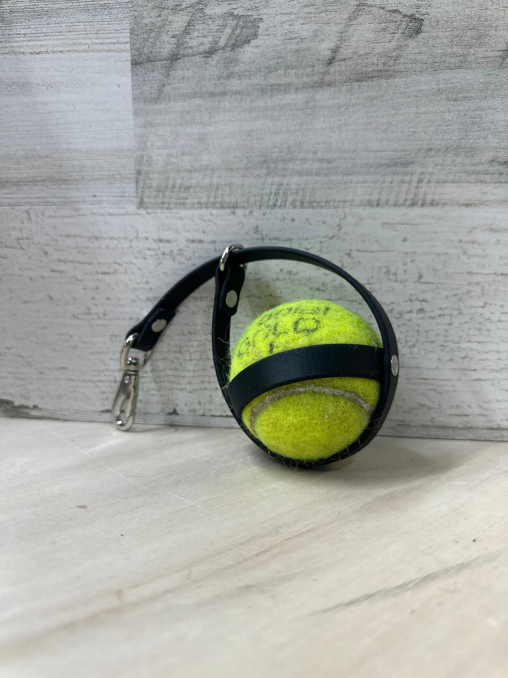 loose tennis ball holder sitting on the gound