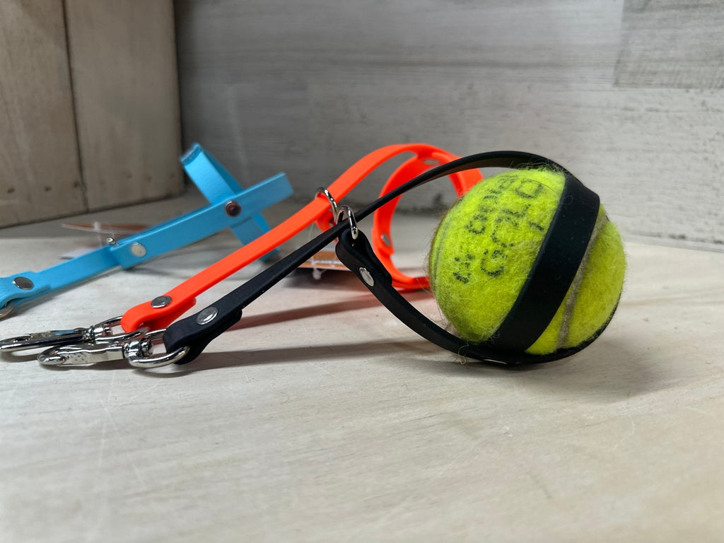 2 empty tennis ball holders and one with a ball