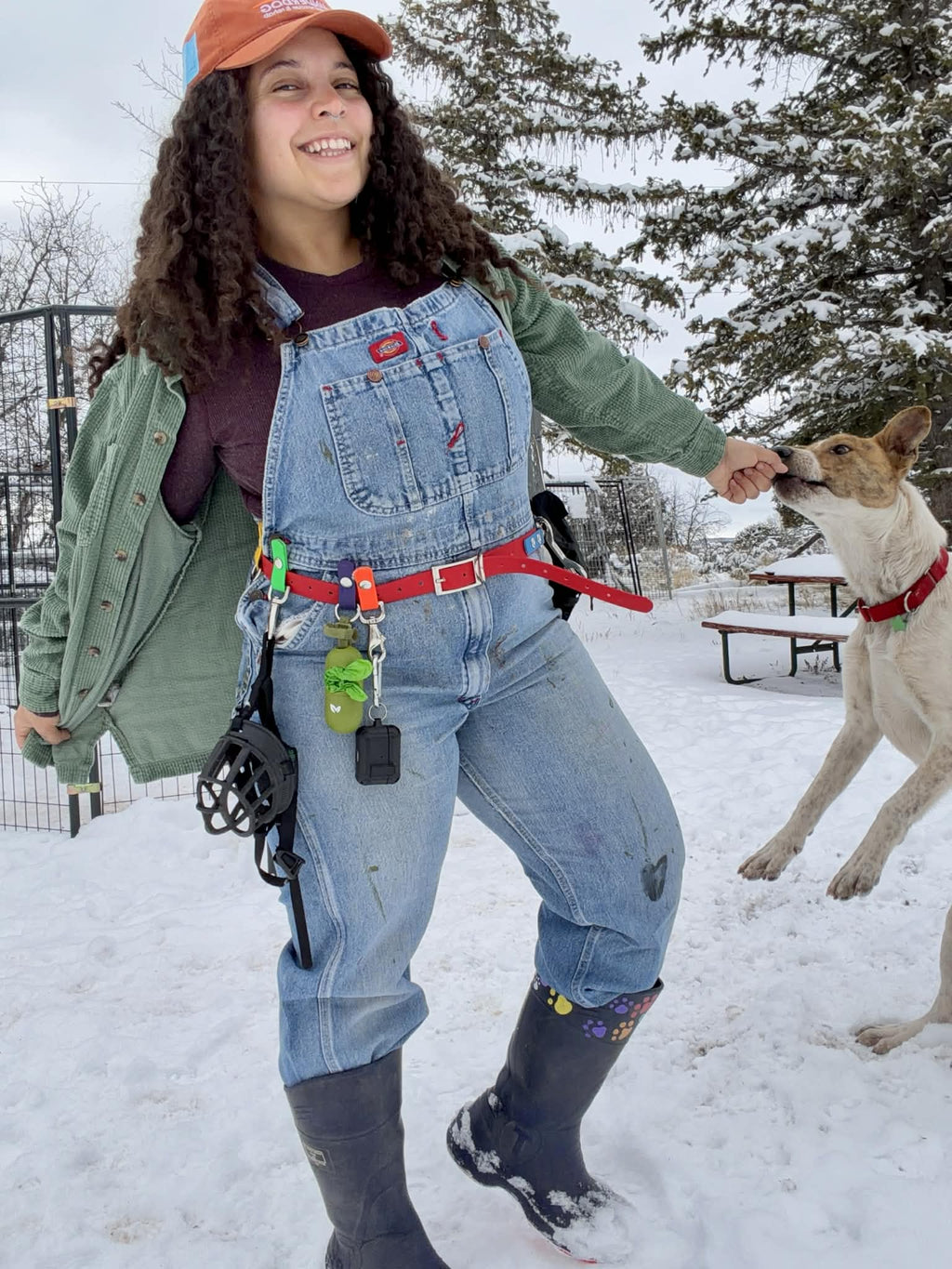 woman wearng biothane training belt with poop bag holder attached and dog next to her